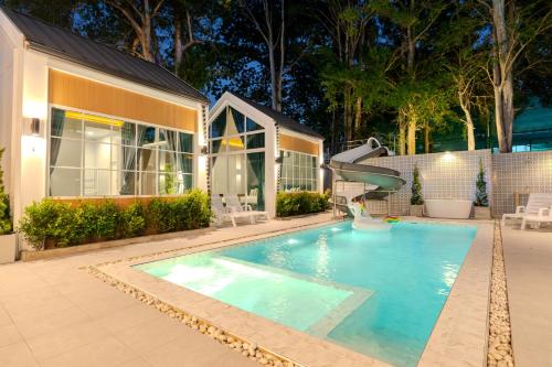 a swimming pool with a slide in front of a house at The Sand and I Private Pool Villa Huahin in Hua Hin