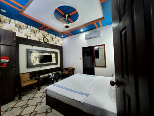 a bedroom with a bed and a clock on the ceiling at Karachi Guest House in Karachi