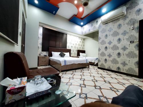 a hotel room with two beds and a table at Karachi Guest House in Karachi