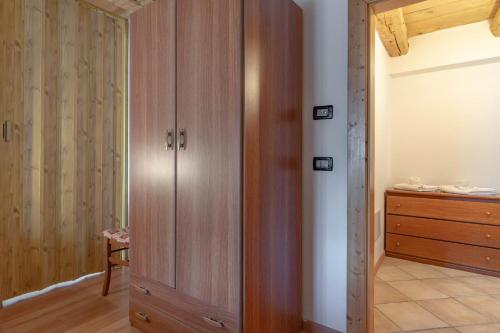 a room with a wooden closet and a dresser at Chalet Musiera in Telve