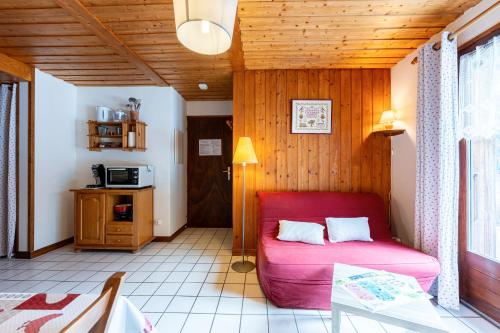 - un salon avec un canapé rouge dans l'établissement Les Niverolles, à La Giettaz