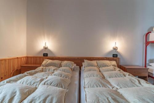 a row of beds in a room with lights on the wall at Chalet Musiera in Telve