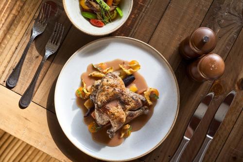 a plate of food with meat and sauce on a table at Courtyard by Marriott Aruba Resort in Palm-Eagle Beach