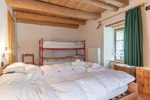 a large white bed in a room with a green curtain at Chalet Musiera in Telve