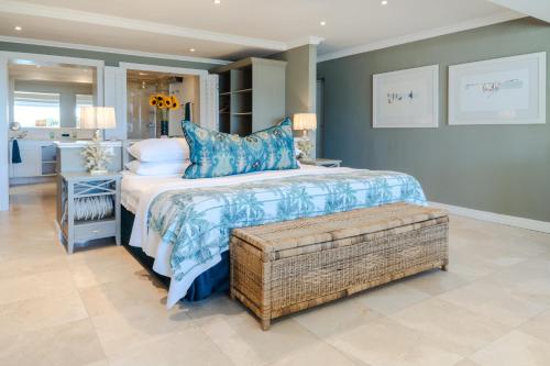 a bedroom with a large bed with blue pillows at Last Word Long Beach in Kommetjie