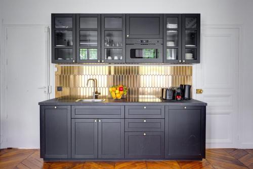 - une cuisine avec des placards noirs et un évier dans l'établissement Bluestay 124 - Superb apartment in Paris, à Paris