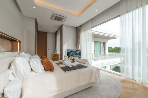 a large white bed in a room with a large window at Nature's Rest Private Pool Villa Rawai in Rawai Beach