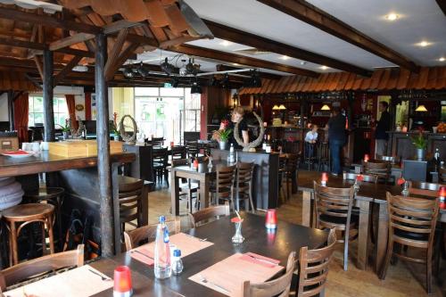 a restaurant with tables and chairs and a bar at Your Private Zeeland Getaway - Cosy Home With Large Garden in Heinkensand