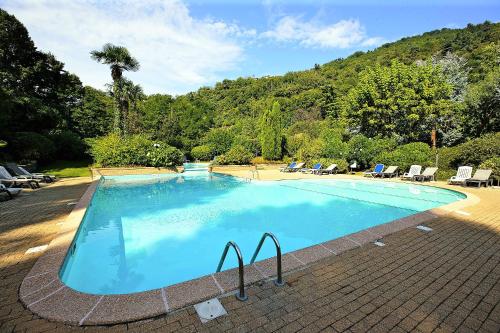 a large blue swimming pool with chairs and trees at Residenz Villa Ada Troubetzkoy in Ghiffa