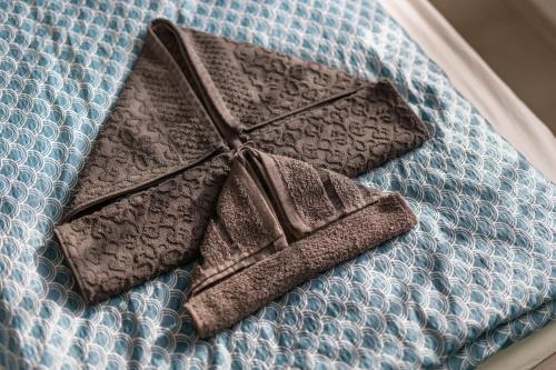 een bed met twee bruine handdoeken erop bij Dream Apartman Aliga II in Balatonvilágos