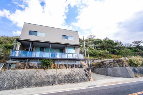 a house on a hill with a fence in front of it at Awaji Ocean View in Kusaka in Awaji