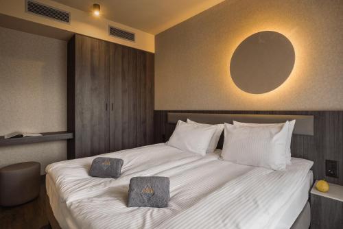 a bedroom with a large white bed with two boxes on it at Termy Karkonosze Resort & Spa koło Karpacza in Staniszów
