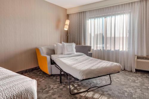 a hotel room with a bed and a window at Courtyard by Marriot Cranbury South Brunswick in Cranbury