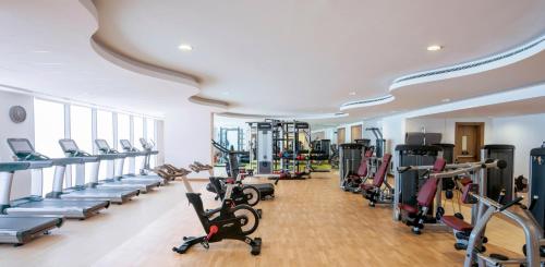a gym with rows of exercise bikes and treadmills at Opulent Residences at Kempinski Muscat in Muscat