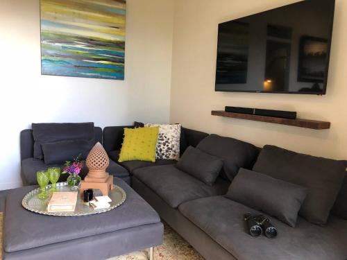 un soggiorno con un divano e un tavolo di Jardin Tiny House Australia a Beechmont