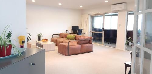 a living room with a couch and a television at Happy room for you in Auckland
