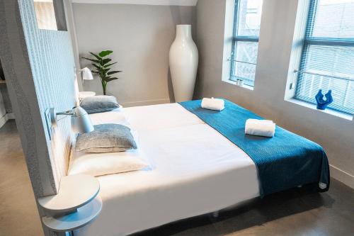 a bedroom with a large bed with a blue blanket at Bed En Koffie Oss Stylish Room In Historic Weaving in Oss