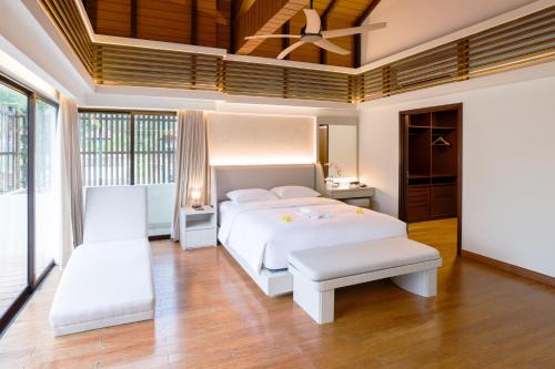 a bedroom with a white bed and a ceiling fan at Pantai Indah Lagoi Bintan in Lagoi