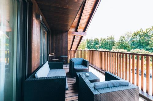 a porch with couches and chairs on a deck at Hotel Das Essigmanngut in Anif