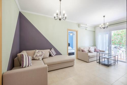a living room with a couch and a table at Icon Deluxe accommodation in Pefkochori