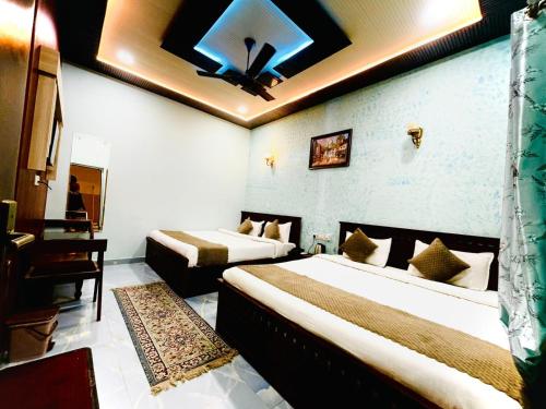 a hotel room with two beds in a room at Hotel Shri Keshav Haveli in Khātu