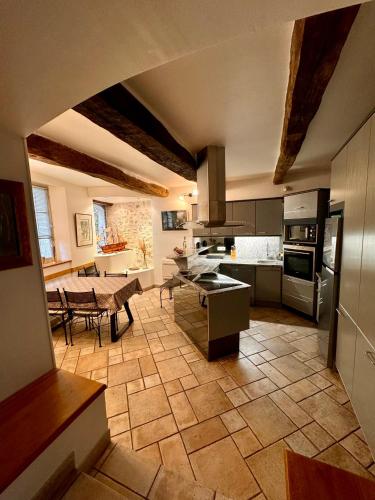 une grande cuisine avec une table et un comptoir dans l'établissement L'élégante - maison de ville avec bains à remous - parking inclus, à Saint-Paul-de-Vence