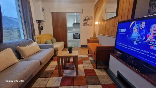 a living room with a large flat screen tv at 5 Bed Plymouth Home-Free Parking - Close to City Centre in Plymouth