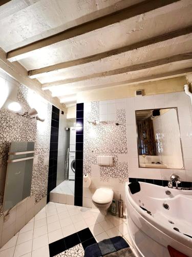 une salle de bain avec toilettes, baignoire et lavabo dans l'établissement L'élégante - maison de ville avec bains à remous - parking inclus, à Saint-Paul-de-Vence