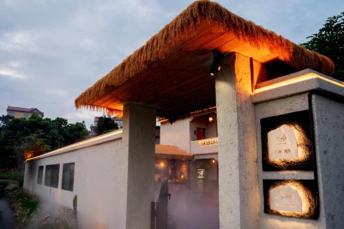 a building with a thatch roof on top of it at 湄洲岛泊澜清风民宿 in Putian