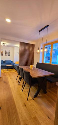 a dining room with a wooden table and chairs at Poku bajka in Kranjska Gora
