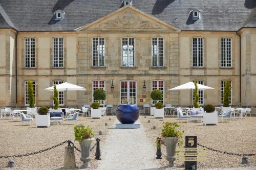 a large building with a large blue vase in the courtyard at Chateau d'Audrieu in Audrieu