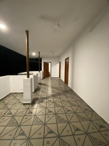 a hallway with a tile floor and white walls at Half Orangee Party Stay with Free Swimming Pool, Free Game Room, Free Parking Next to Vagator Beach-Near to Chapora Fort-Near to Hill Top -Best for Couples-Backpackers, Long stays, Coworking, Day-use with Game zone and summer vacation!! in Vagator