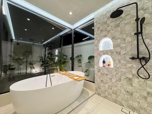 a large bathroom with a tub and a shower at Villa Paapa & Maama in Johor Bahru