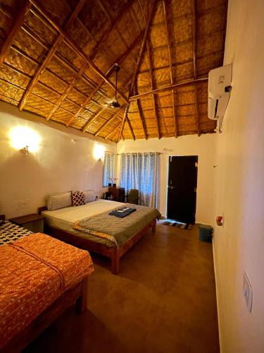 a bedroom with two beds in a room at Khushi's Cottage in Hampi