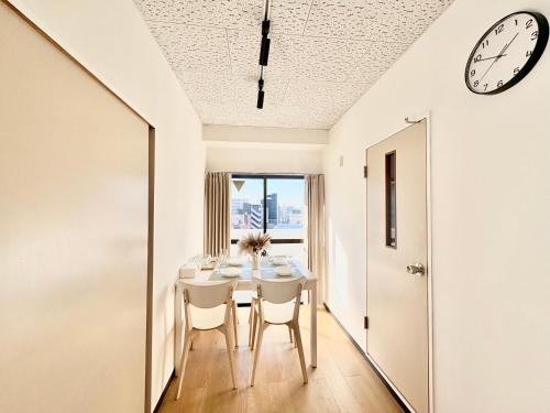 a dining room with a table and a clock on the ceiling at Emoto Asakusa in Tokyo