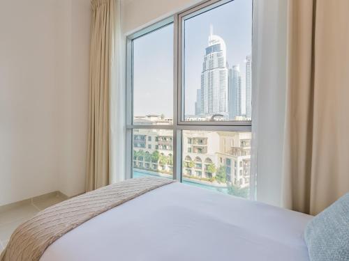 a bedroom with a bed and a large window at the Byron Bay condo in Dubai