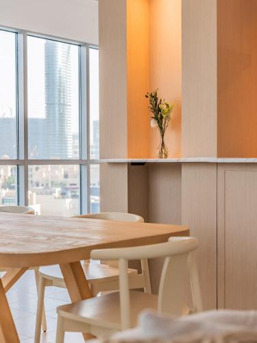 a table and chairs with a vase of flowers in a room at the Byron Bay condo in Dubai