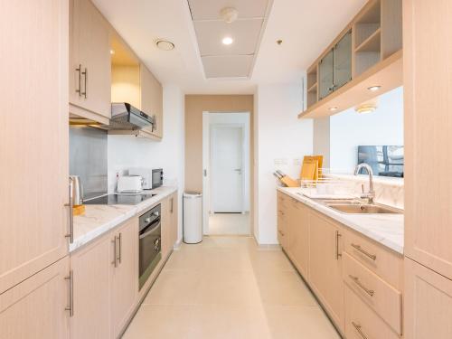 a large kitchen with white cabinets and appliances at the Byron Bay condo in Dubai