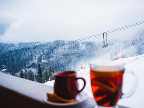 a cup of tea and a cup of coffee with a ski lift at Apartamenty na Soszowie, Wisła - widokowe miejsce z Balią & Prywatną Sauną, obok stoku narciarskiego i Bike Parku, dla max 16 osób in Wisła