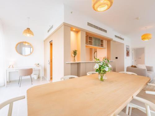 a dining room with a wooden table and chairs at the Byron Bay condo in Dubai