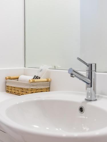 a bathroom sink with a faucet and a mirror at the Byron Bay condo in Dubai