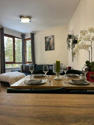 a living room with a table with wine glasses on it at Elizi winter apartments Pamporovo in Pamporovo