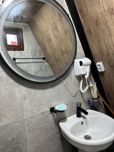 un baño con espejo y lavabo en Wood Vibe, en Merisi