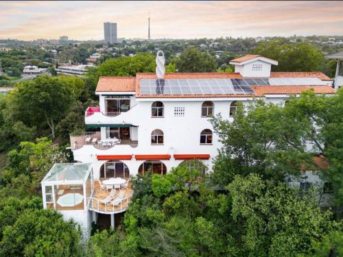 a white house with solar panels on its roof at La Casa Blanca in Johannesburg