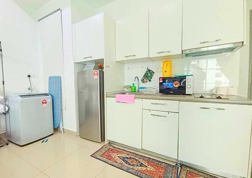 a kitchen with white cabinets and a stainless steel refrigerator at Airly Cybersquare Ensuite with Pool View #CS7 in Cyberjaya