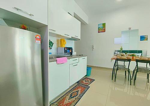 a kitchen with a table and a white refrigerator at Airly Cybersquare Ensuite with Pool View #CS7 in Cyberjaya