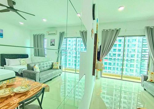 a living room with a couch and a table at Airly Cybersquare Ensuite with Pool View #CS7 in Cyberjaya