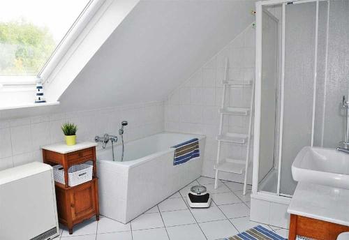 a bathroom with a shower and a tub and a sink at Villa Westwind Ferienwohnung Mala in Landkirchen