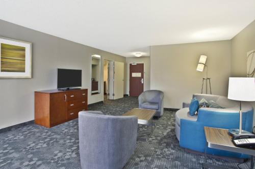 a living room with a couch and a tv at Courtyard by Marriott Gulfport Beachfront in Gulfport