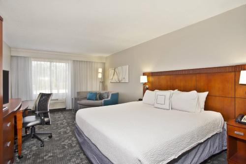 a hotel room with a bed and a desk at Courtyard by Marriott Gulfport Beachfront in Gulfport